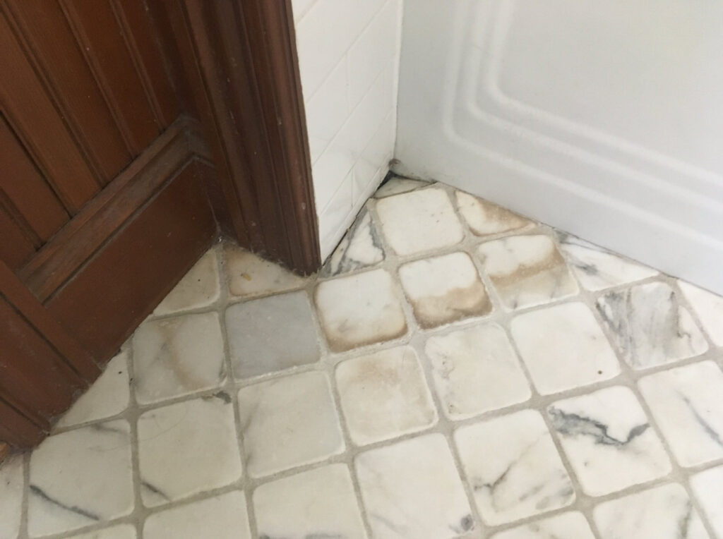 Stained marble tile cleaning, sealing and water damage repair - before image